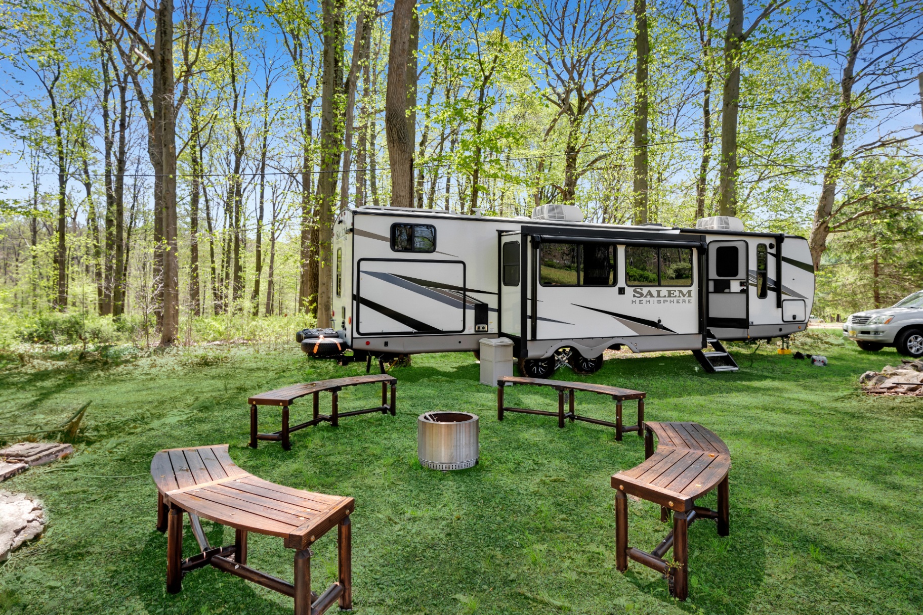The Camp RV and fire pit gathering area in the woods